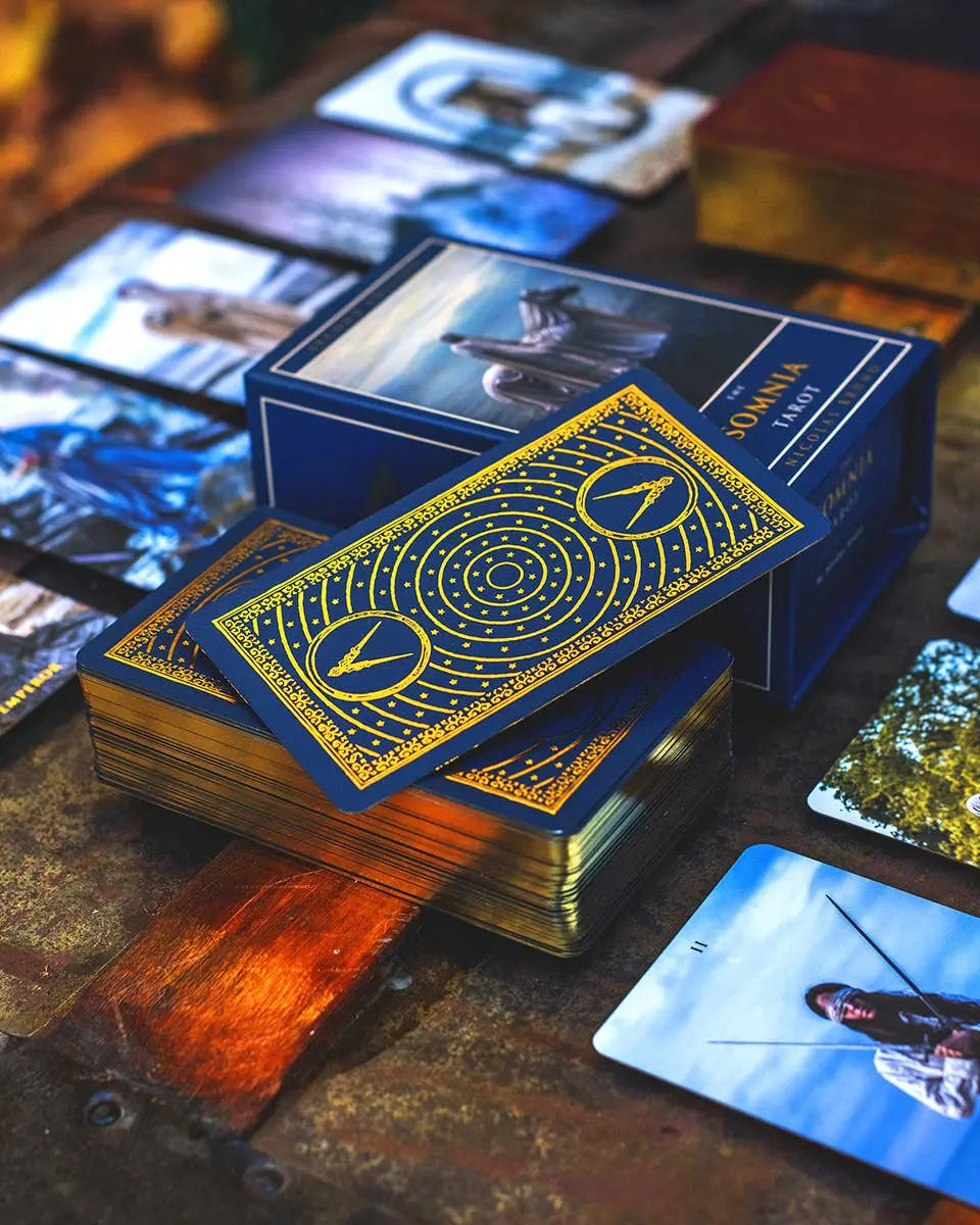 Collection of cards with a blue and gold design on a wooden surface