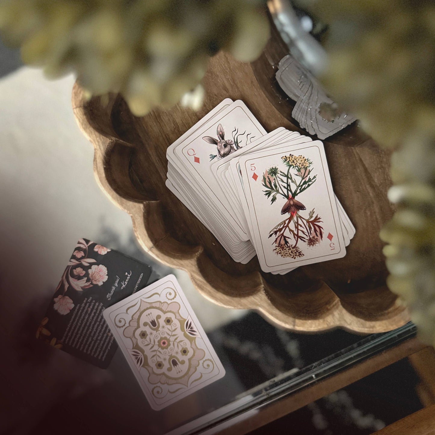 Set of playing cards with nature designs on a glass coffee table