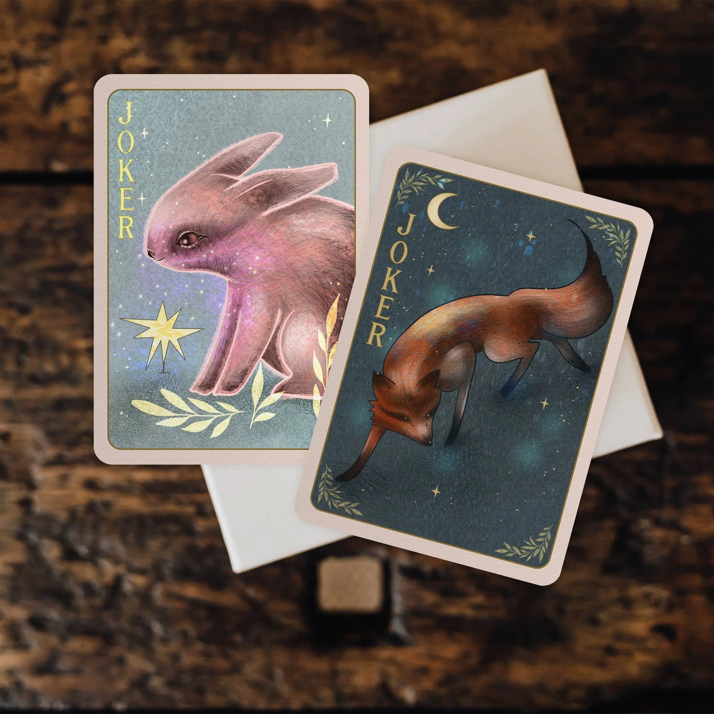 Two tarot cards featuring animal illustrations on a textured surface