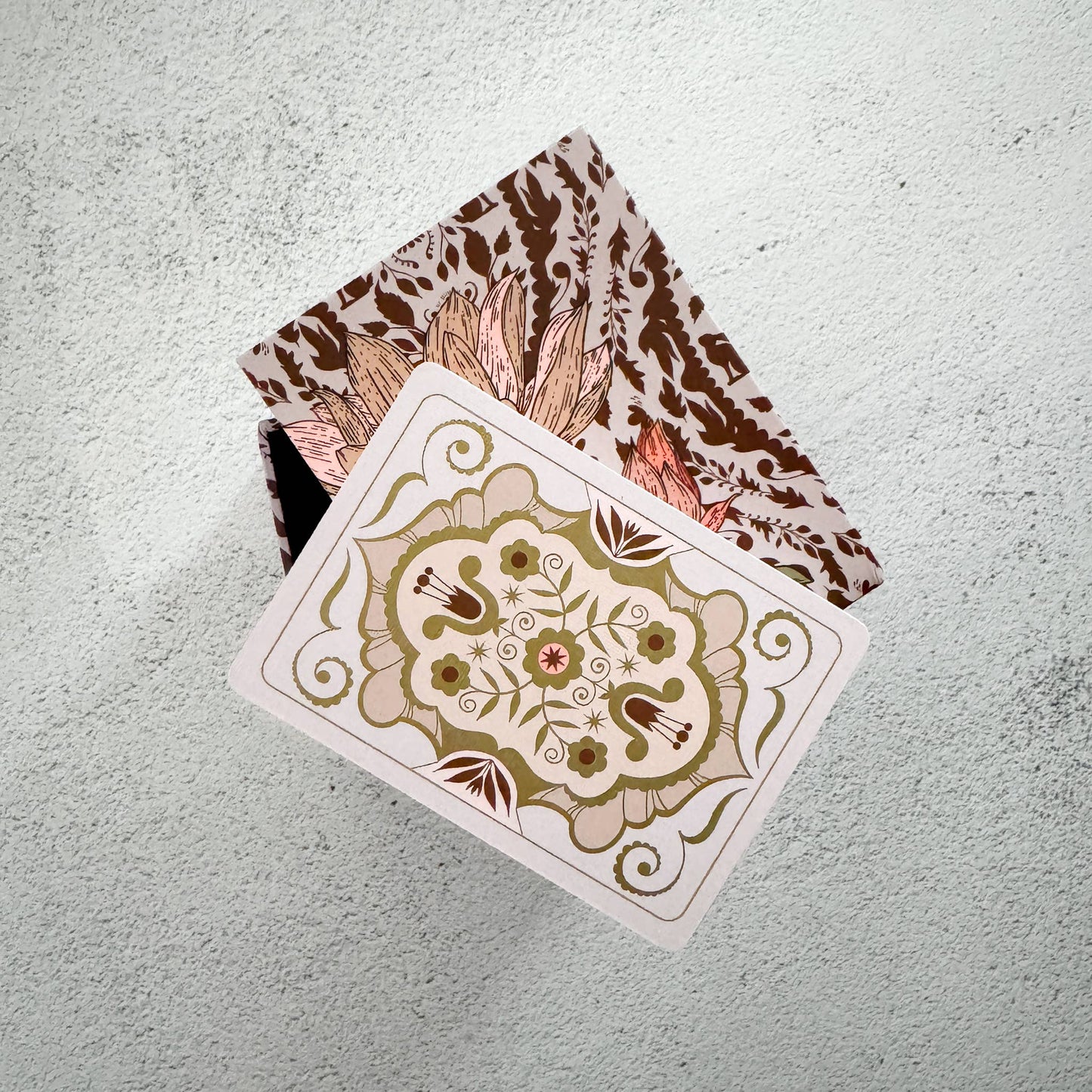 Playing cards with floral design on a textured surface