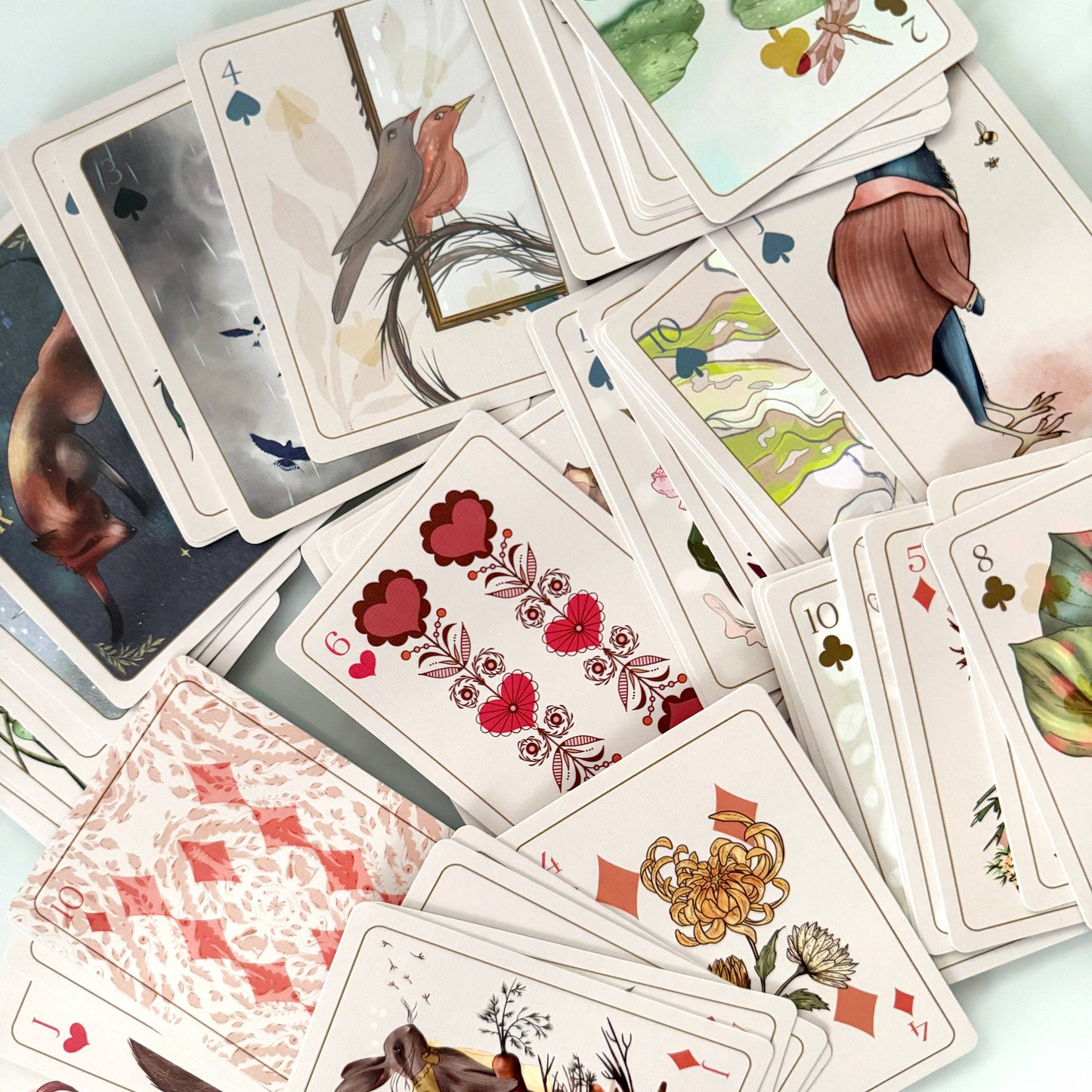 Playing cards with artistic designs on a light background