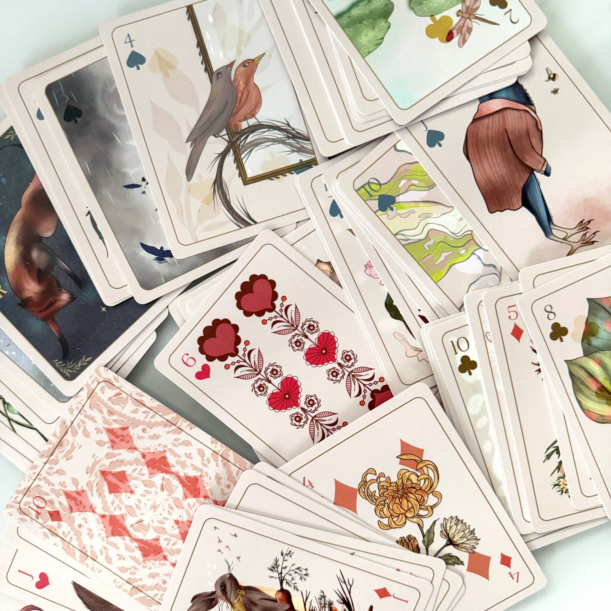 Playing cards with artistic designs on a light background