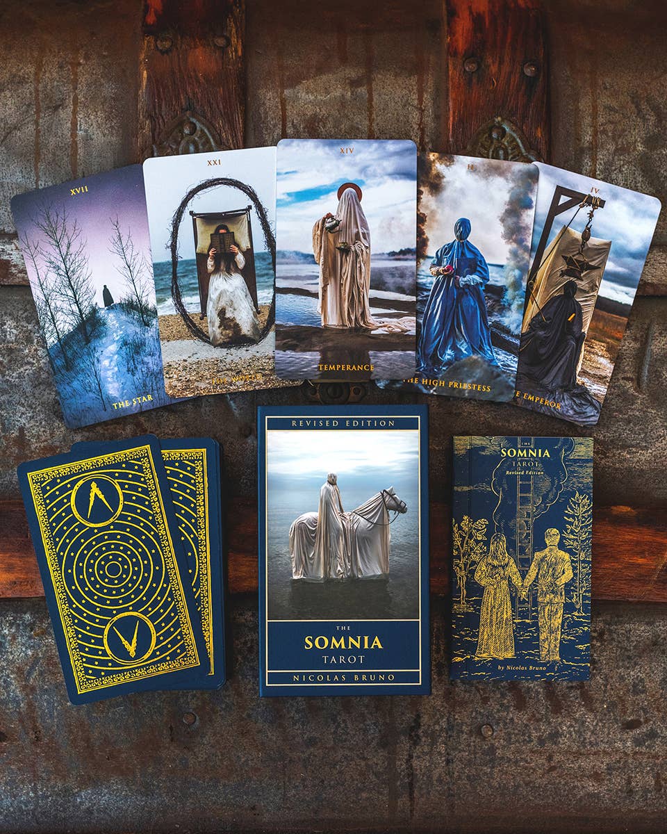 Collection of tarot cards with artistic designs on a rustic wooden background
