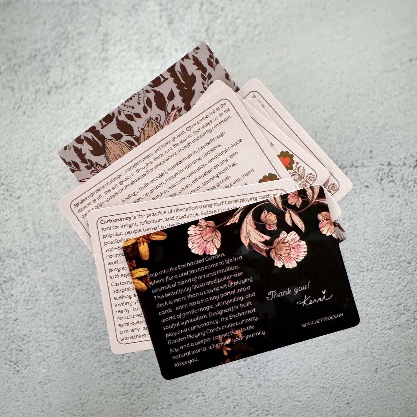 Set of cards with floral designs and text on a textured surface