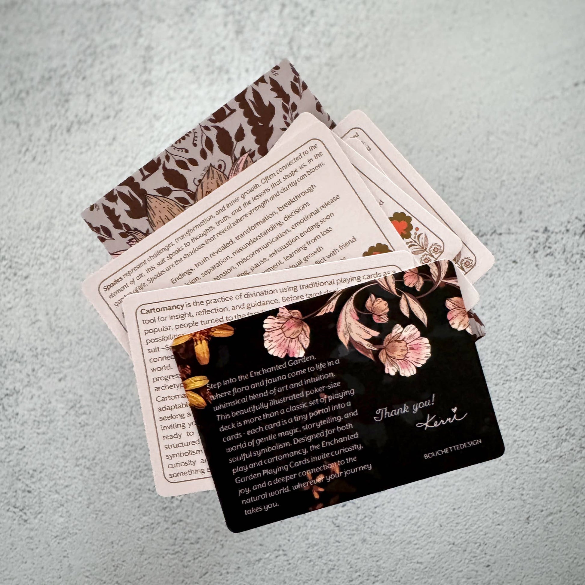 Set of cards with floral designs and text on a textured surface