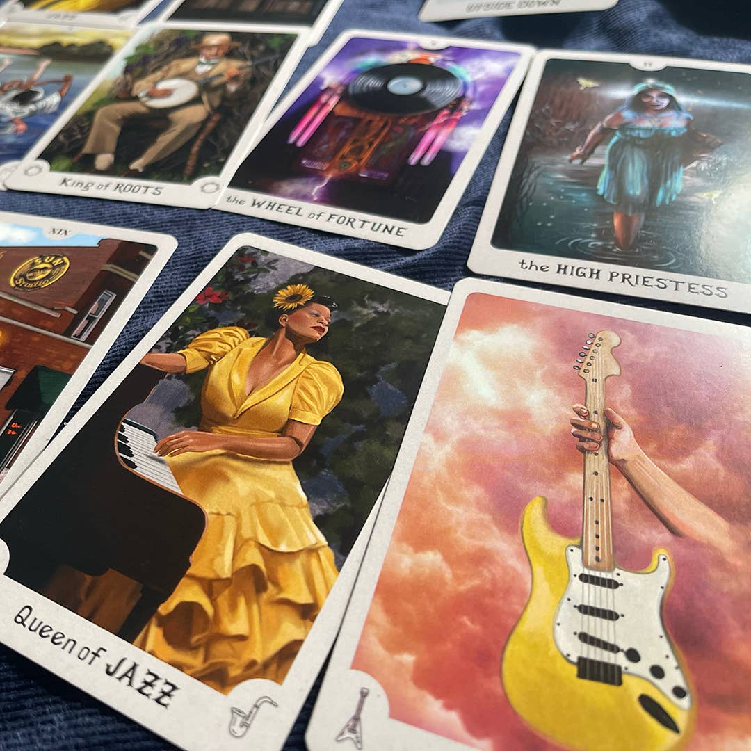 Collection of tarot cards with various illustrations including a woman in a yellow dress, a guitar, and a person on a horse.