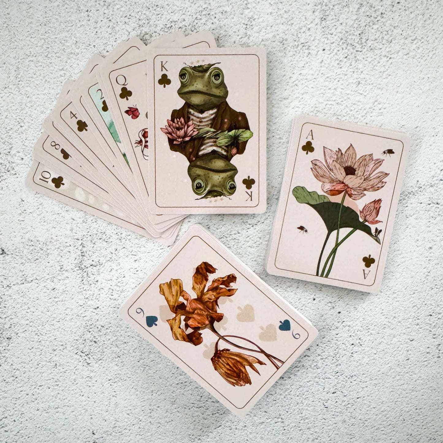Playing cards with nature-themed designs on a textured surface