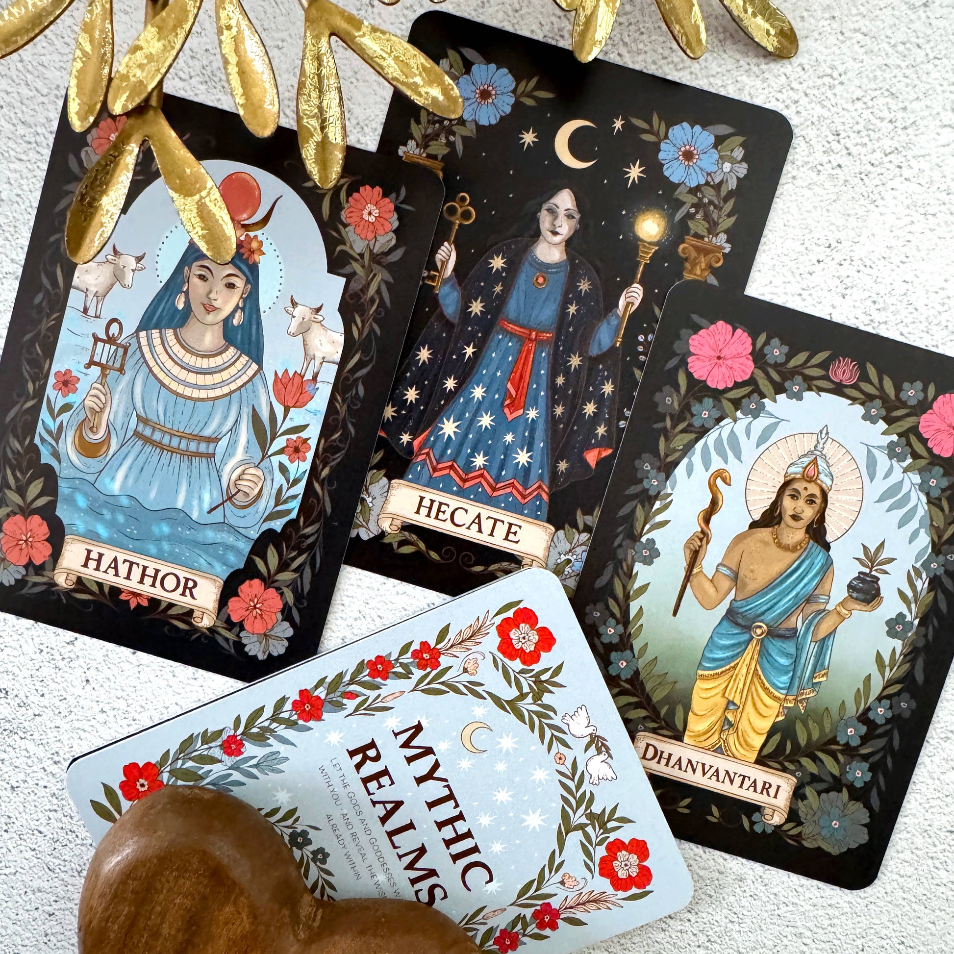 Set of tarot cards featuring deities with decorative elements on a textured surface.
