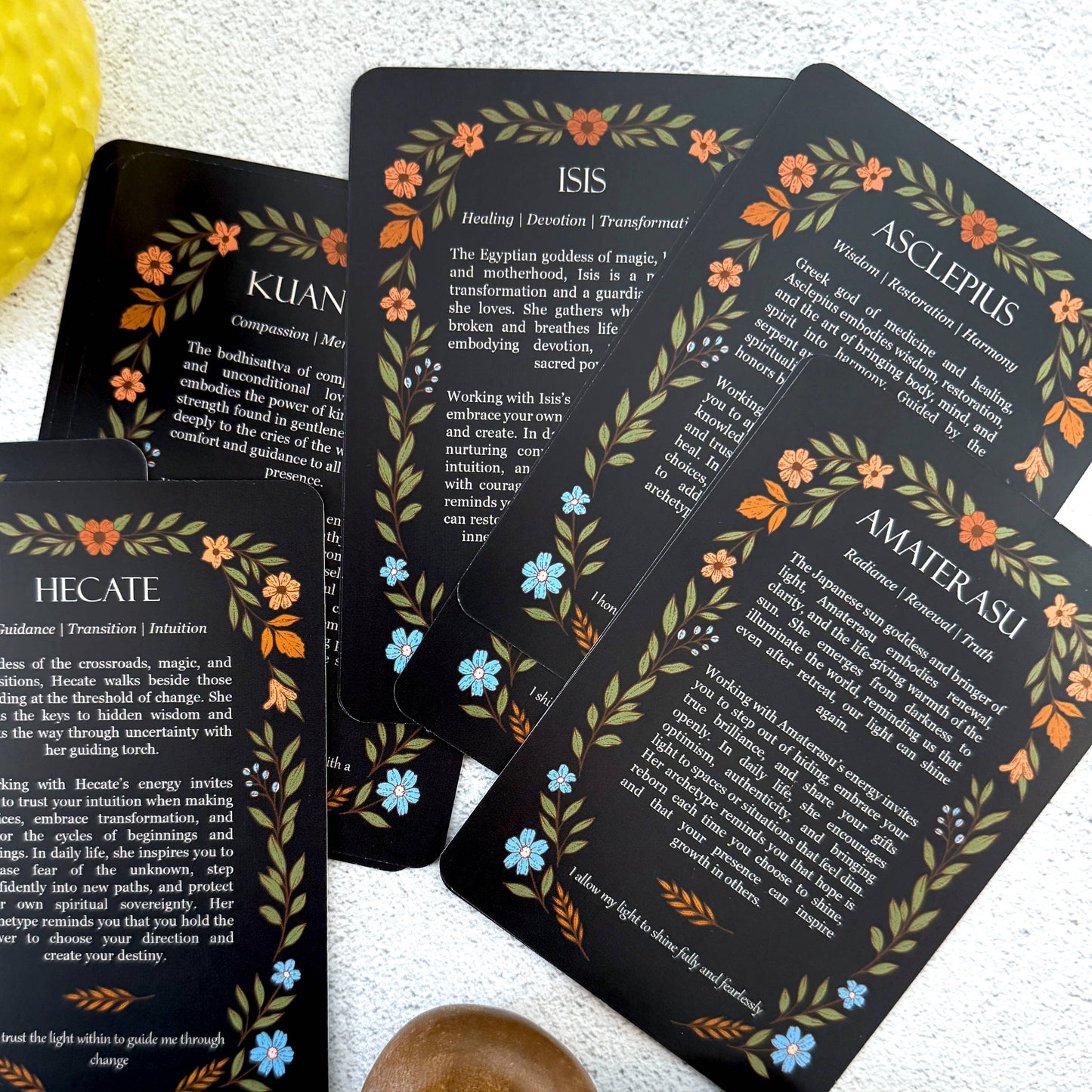 Set of tarot cards with goddess names and descriptions on a white surface.