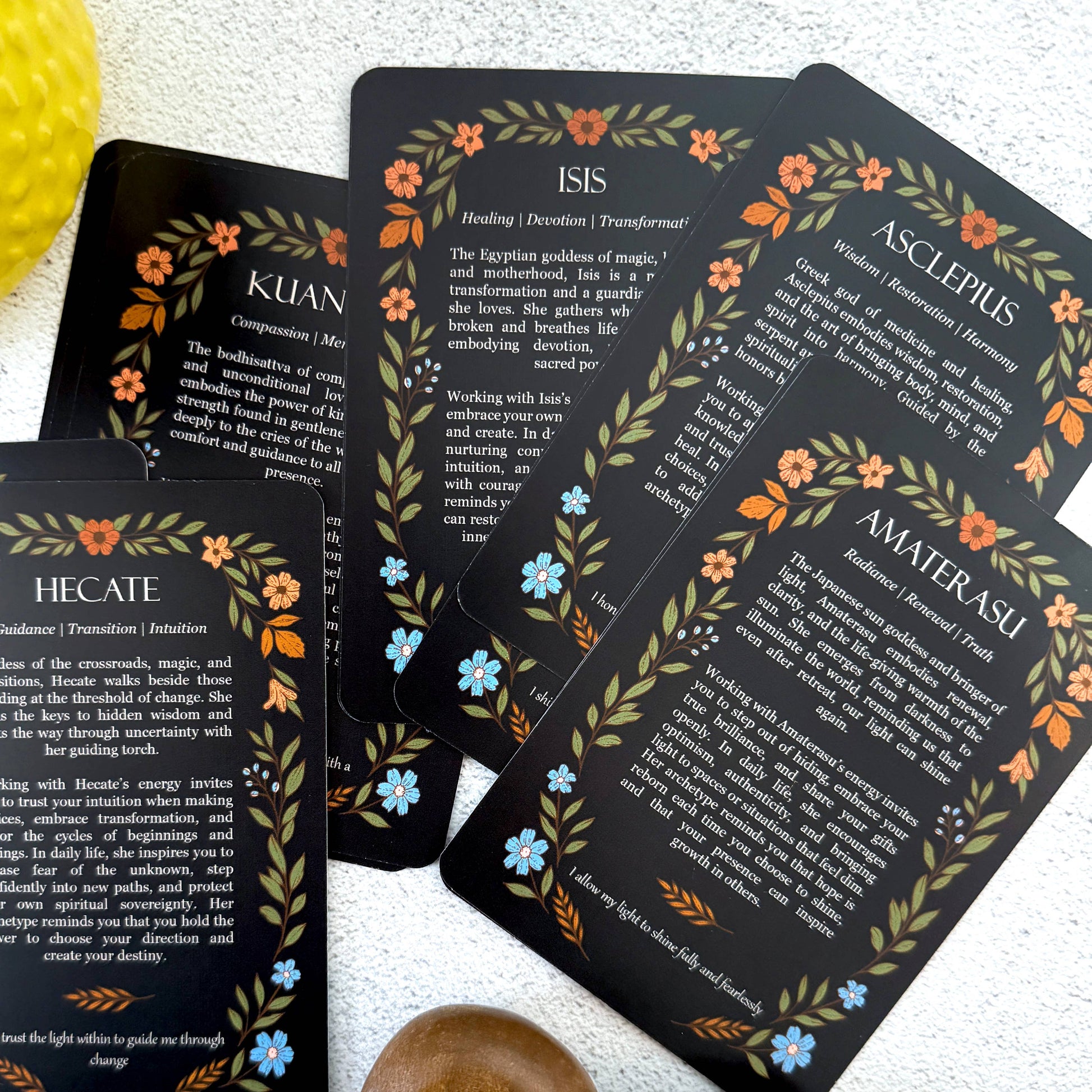 Set of tarot cards with goddess names and descriptions on a white surface.