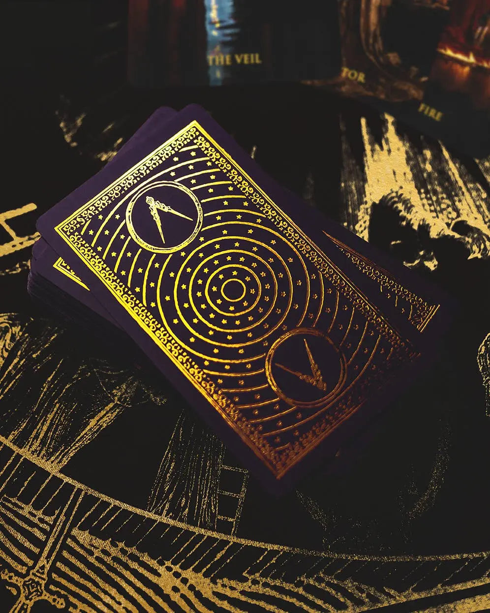 Gold-embossed playing cards with intricate designs on a dark background