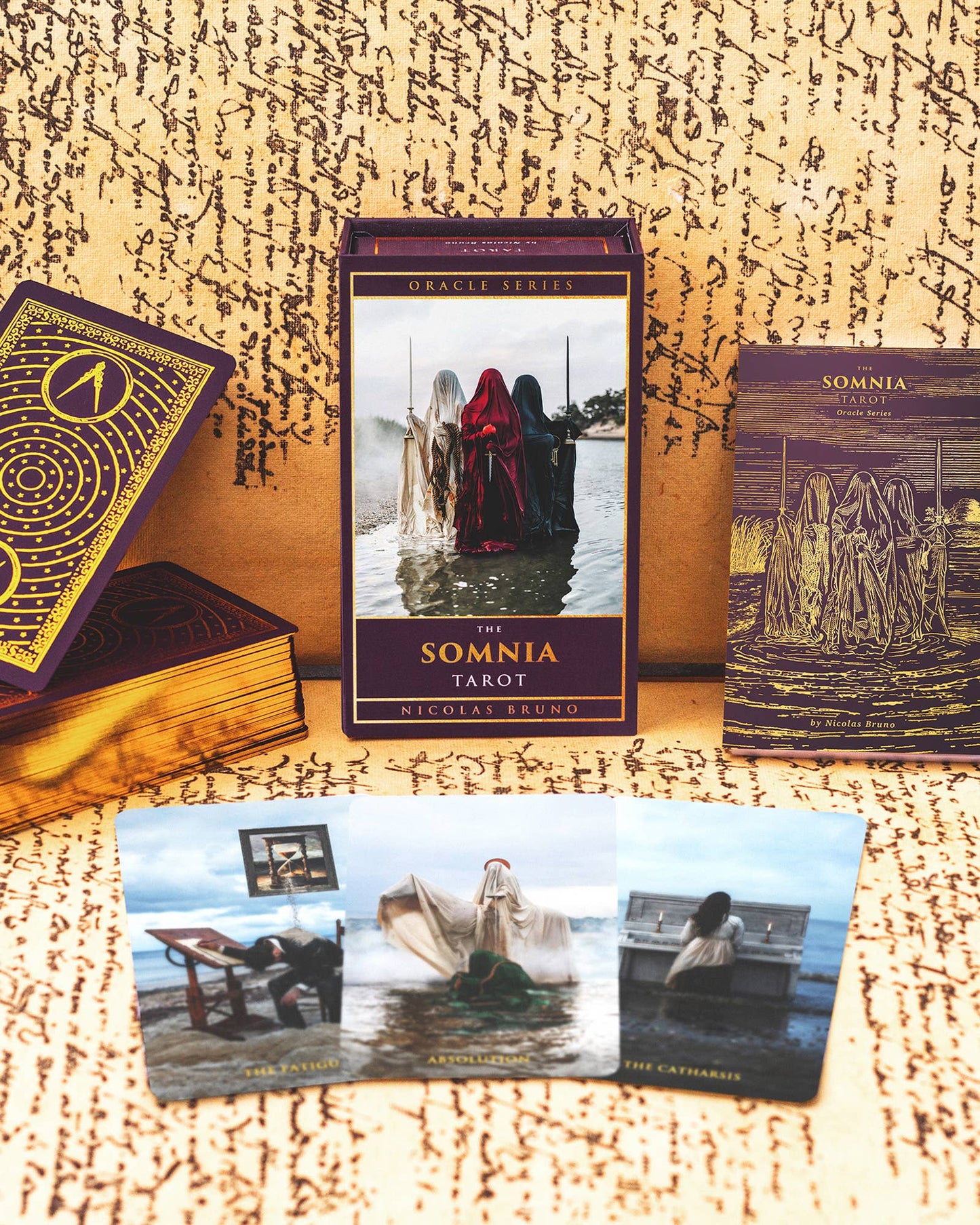 The Somnia Tarot cards and book on a textured surface with a mystical design.