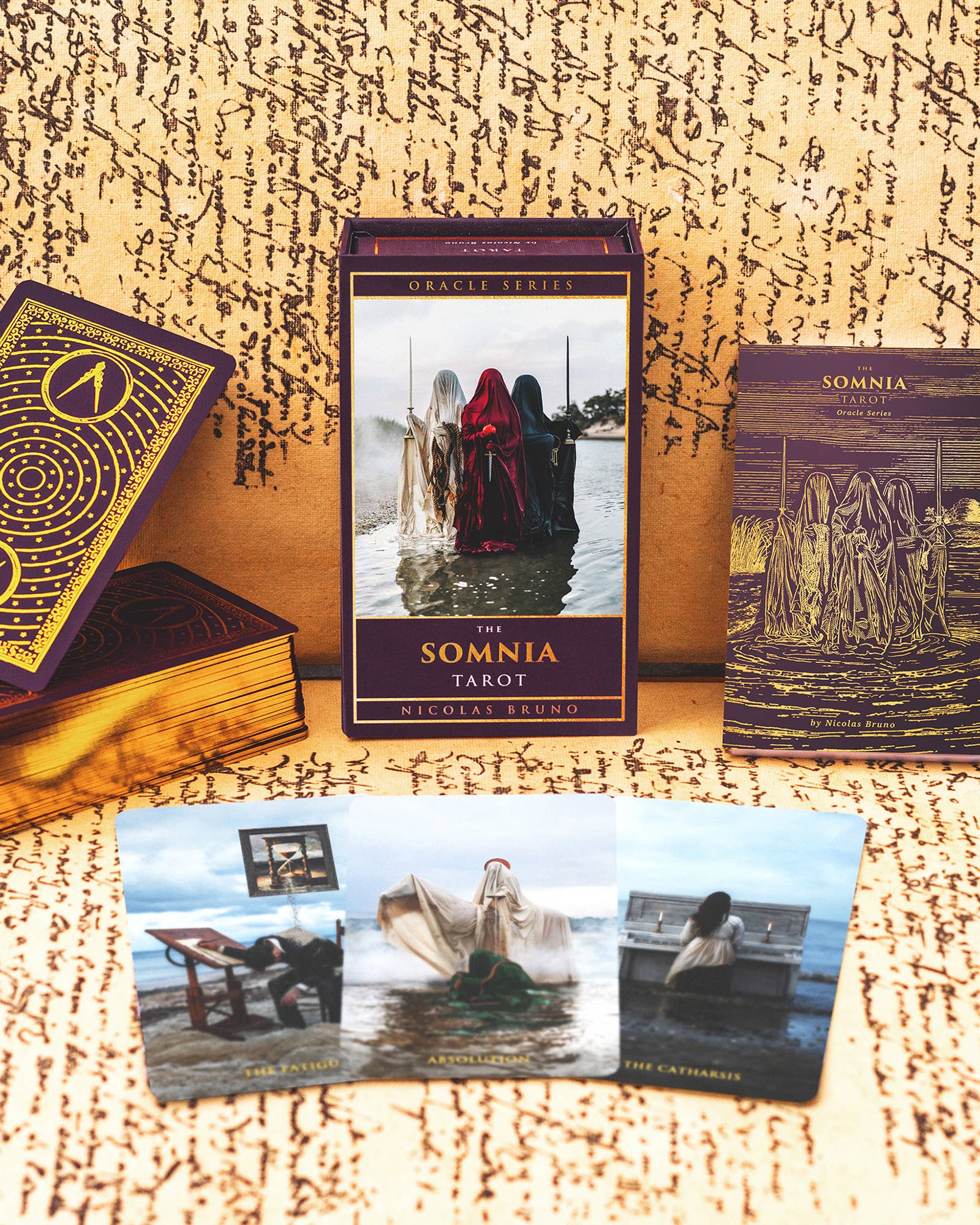 The Somnia Tarot cards and book on a textured surface with a mystical design.