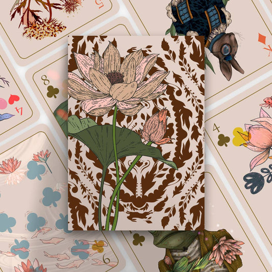 Notebook with floral design on a surface with playing cards