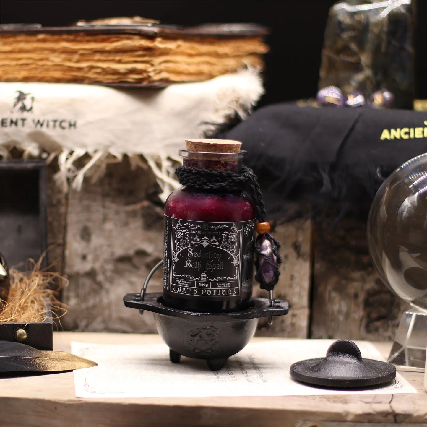 Decorative potion bottle with dark liquid on a wooden surface, surrounded by witch-themed decor.