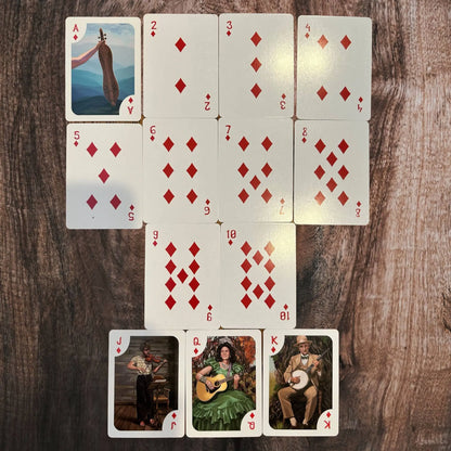 Playing cards with diamond suits arranged in a fan on a wooden surface.
