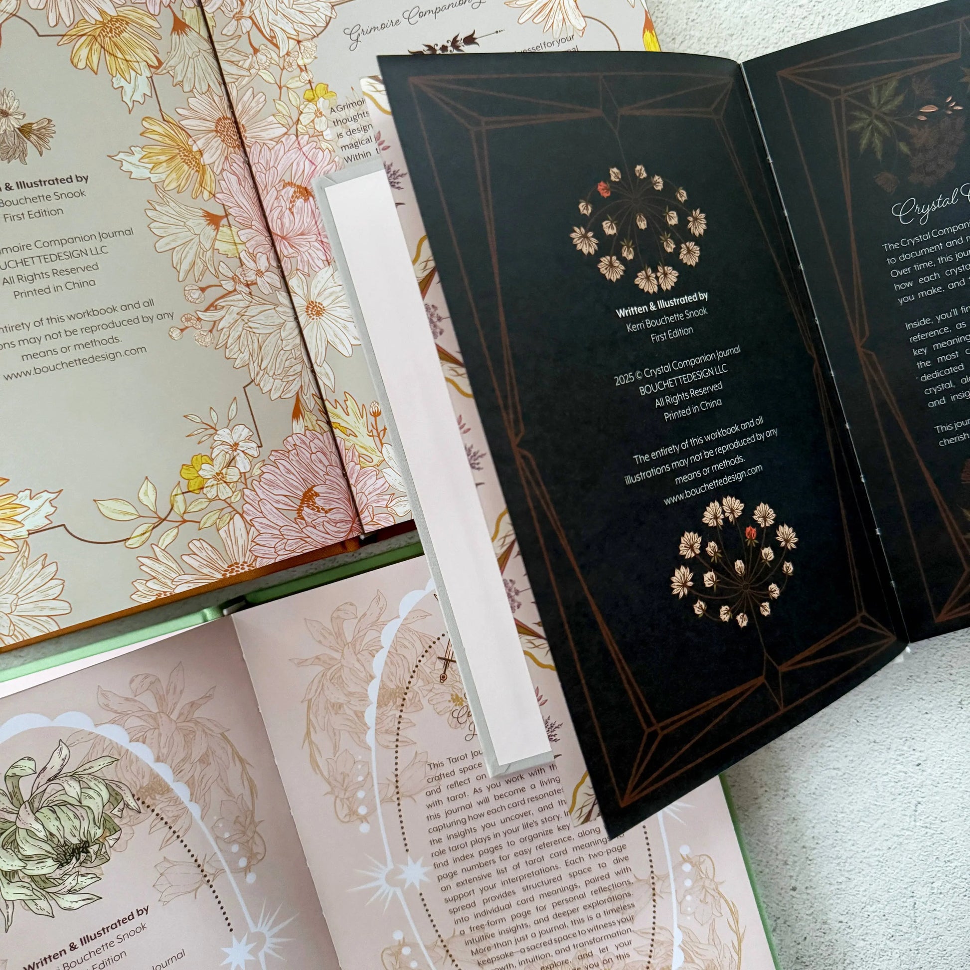 Open book with floral illustrations and a black section with text and designs. Grimoire Bouchette and Co Oneness Emporium