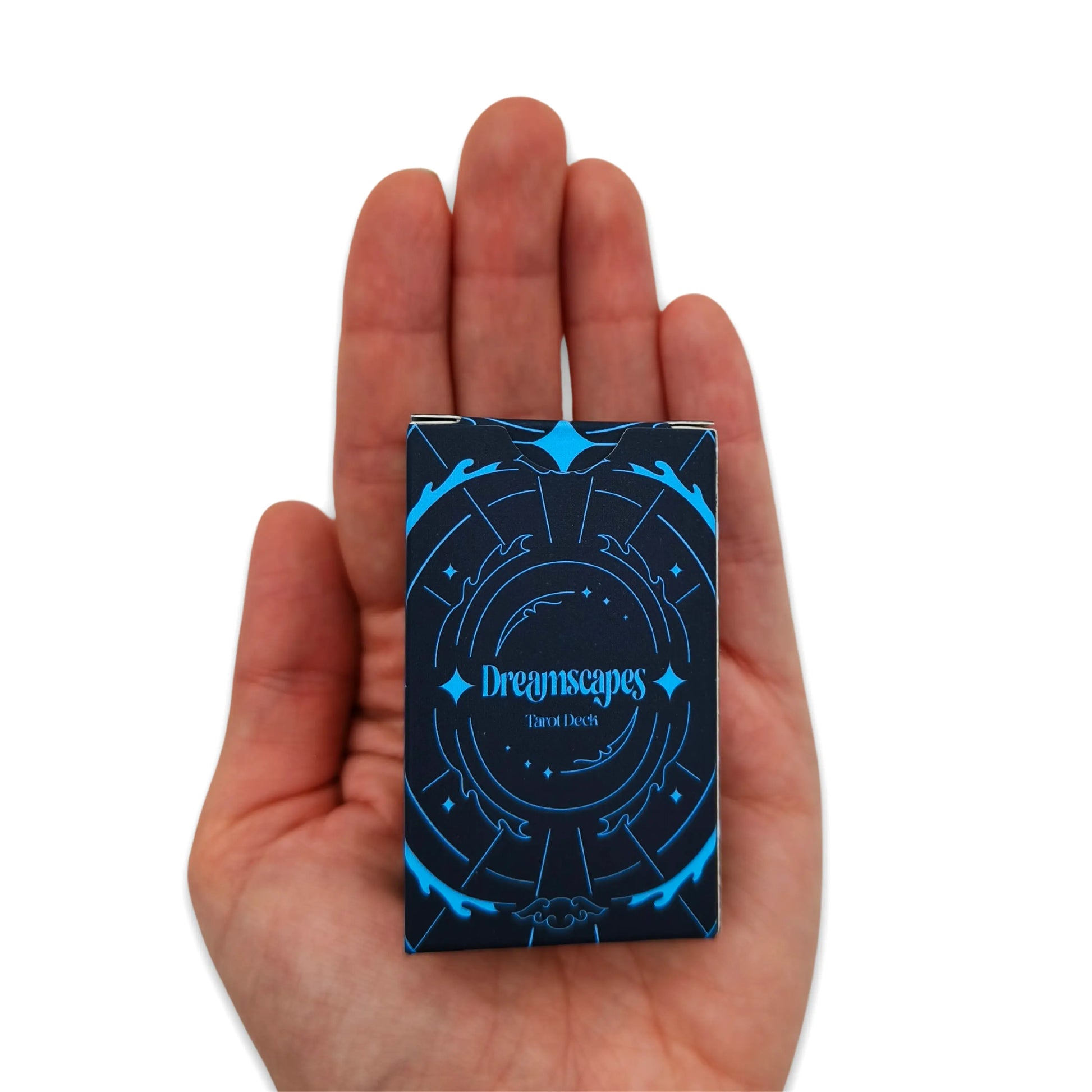 Hand holding a deck of cards with 'Dreamscapes' design on a white background pocket edition