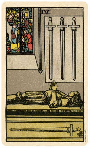 Tarot card with three swords, a figure lying down, and a stained glass window on a beige background.