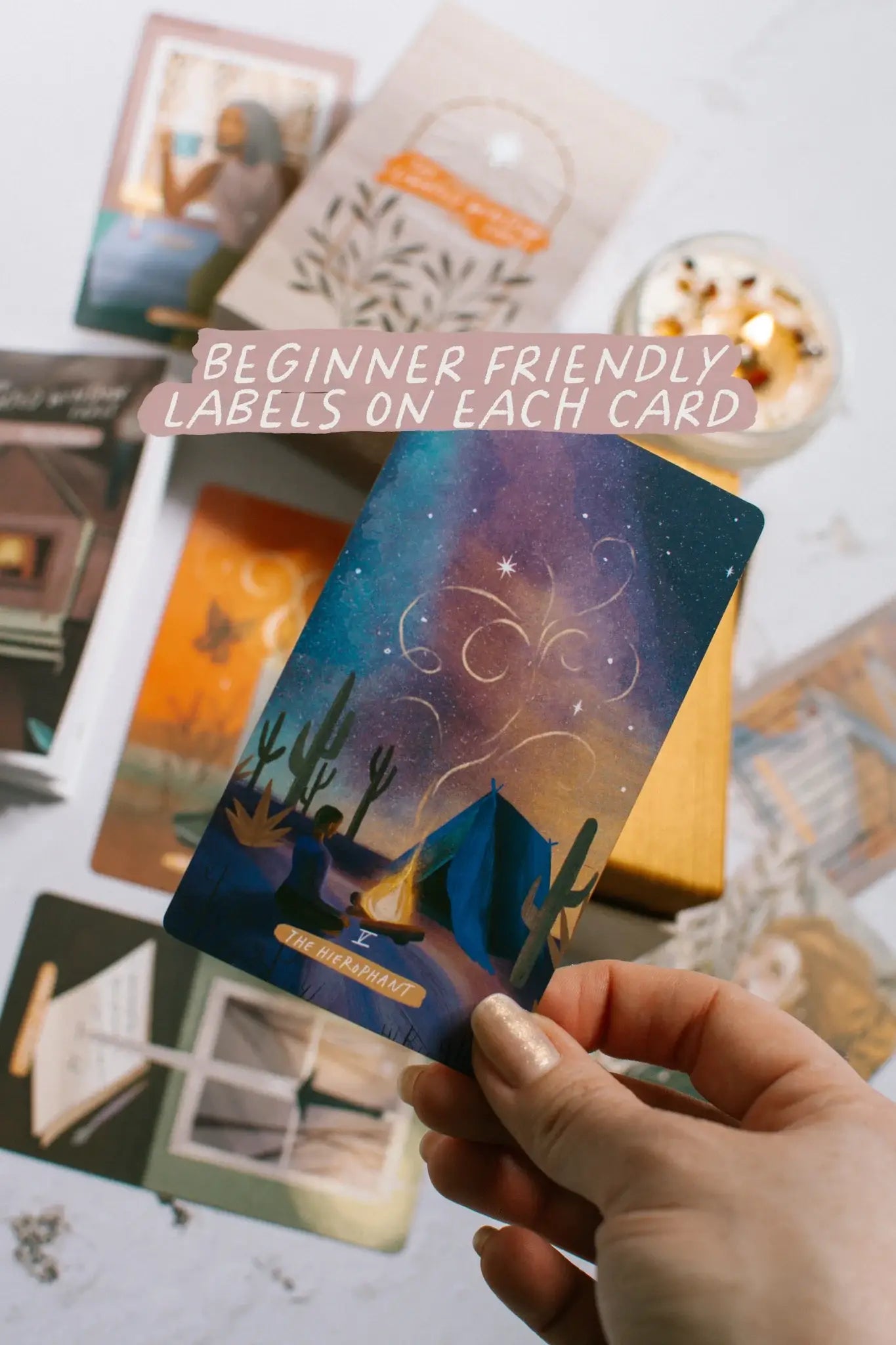 Hand holding a tarot card with other cards in the background, text overlay 'Beginner Friendly Labels on Each Card'.
