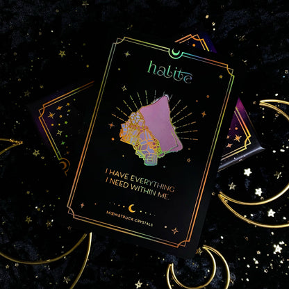 Decorative card with 'halite' branding and celestial design on a dark background with stars and moon symbols. Gold Crystal Affirmations Golden Aura Edition featuring luxury affirmation cards inspired by crystal wisdom, mindfulness, and positive daily intentions.
