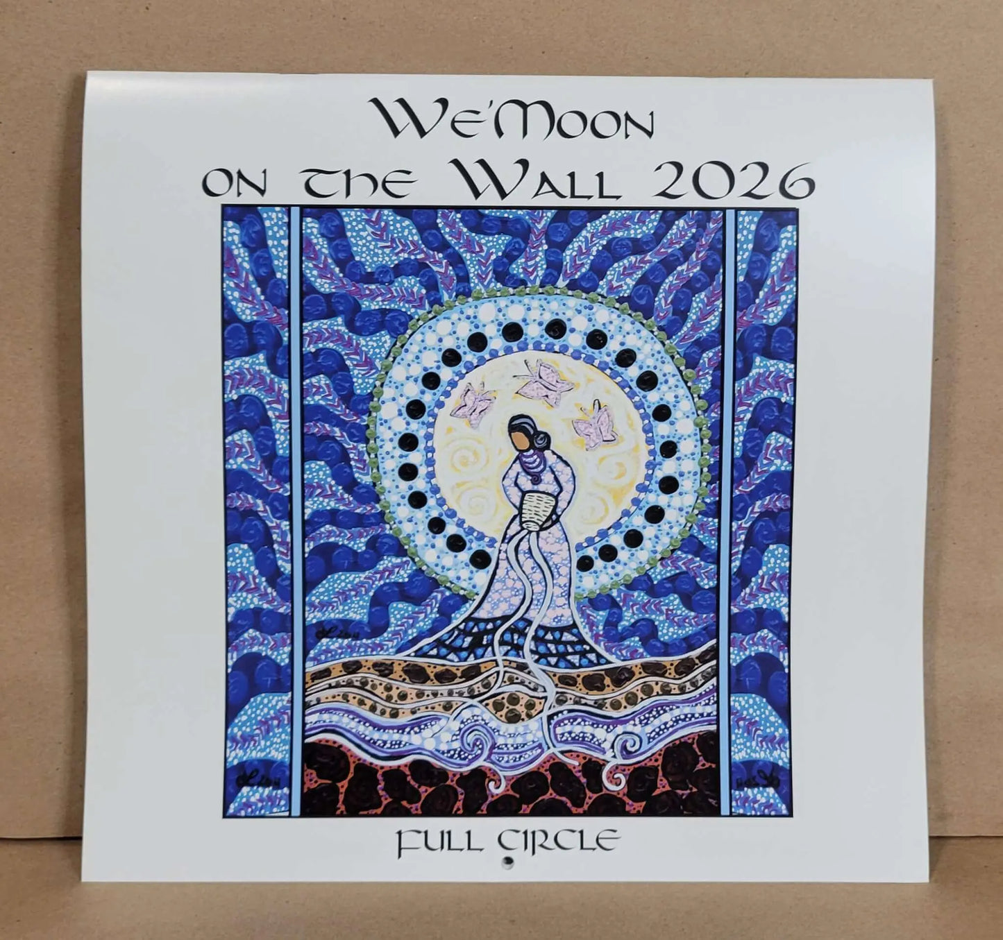 Decorative calendar cover for 'We'Moon on the Wall 2026' with artistic design and text.