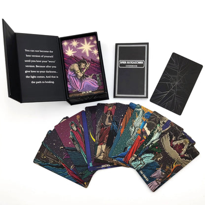 Collection of tarot cards with a deck, book, and card displayed on a white background - Dark reflections tarot by La Muci Available at Oneness Emporium