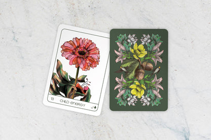 Two tarot cards with floral designs on a light gray surface