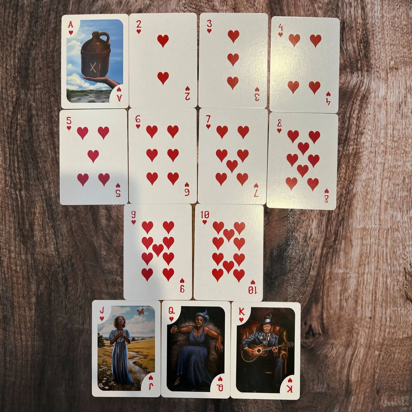 Playing cards with heart symbols on a wooden surface