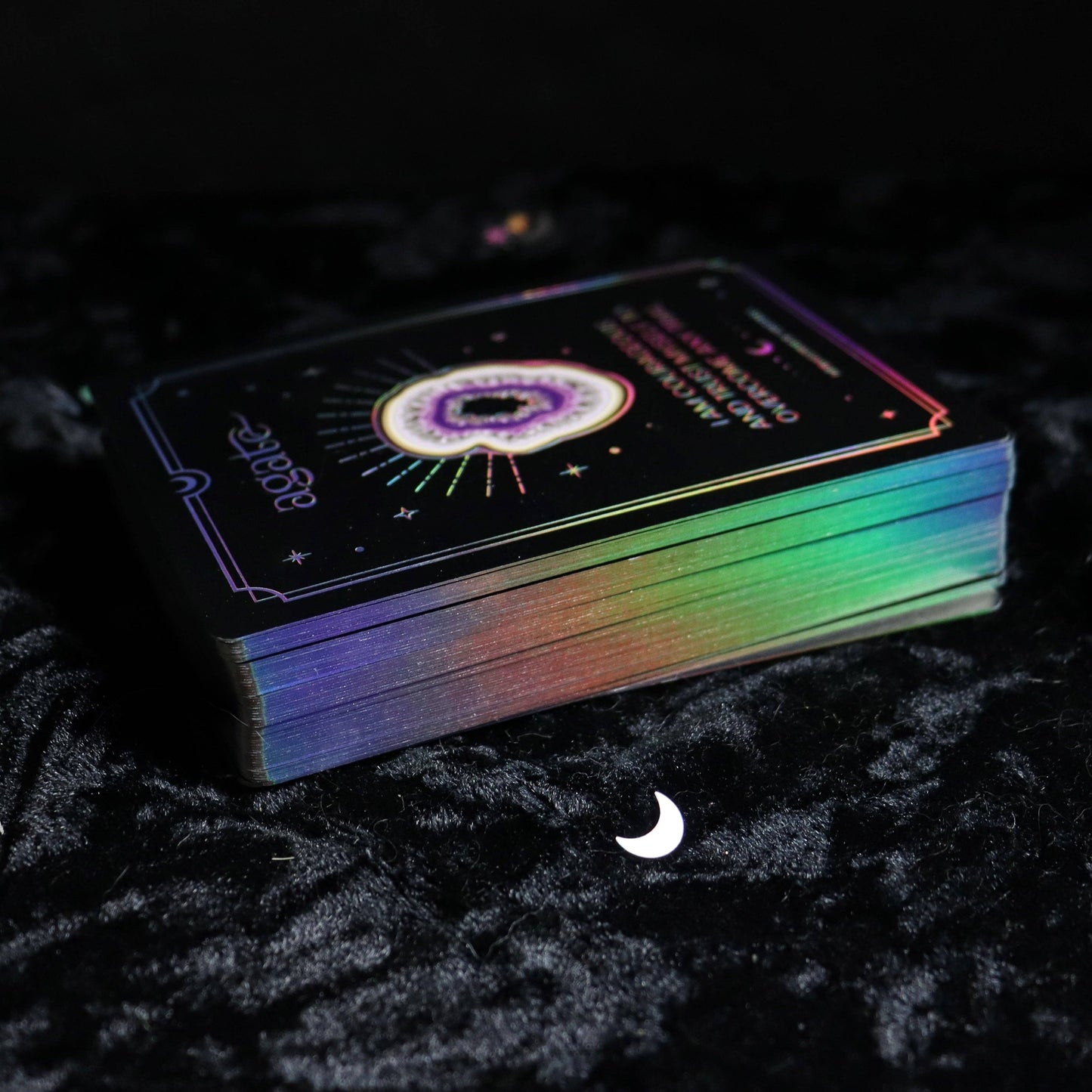 Colorful deck of cards with astrological design on a dark textured surface.