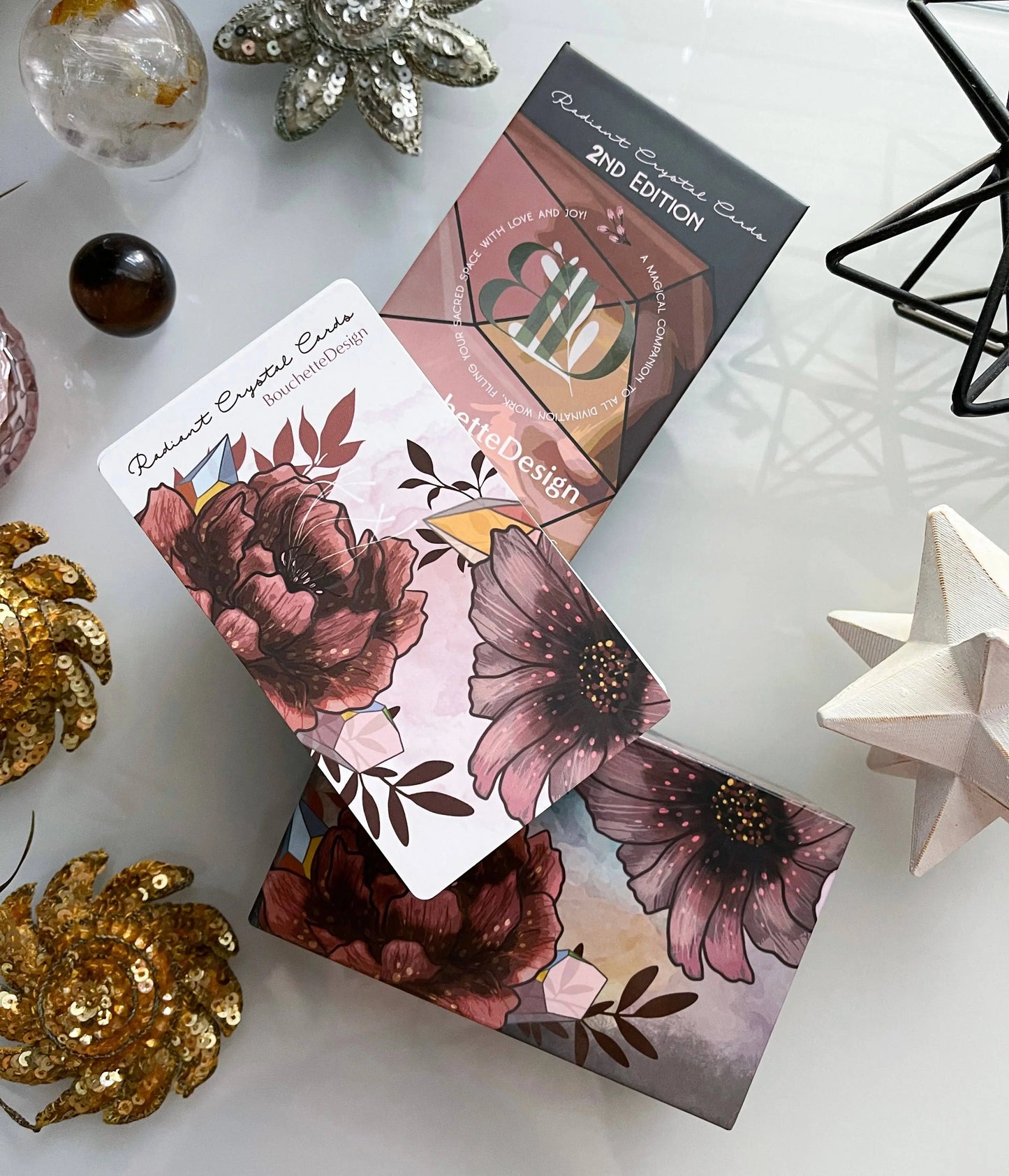 Floral design cards on a white surface with decorative items. radiant crystal oracle