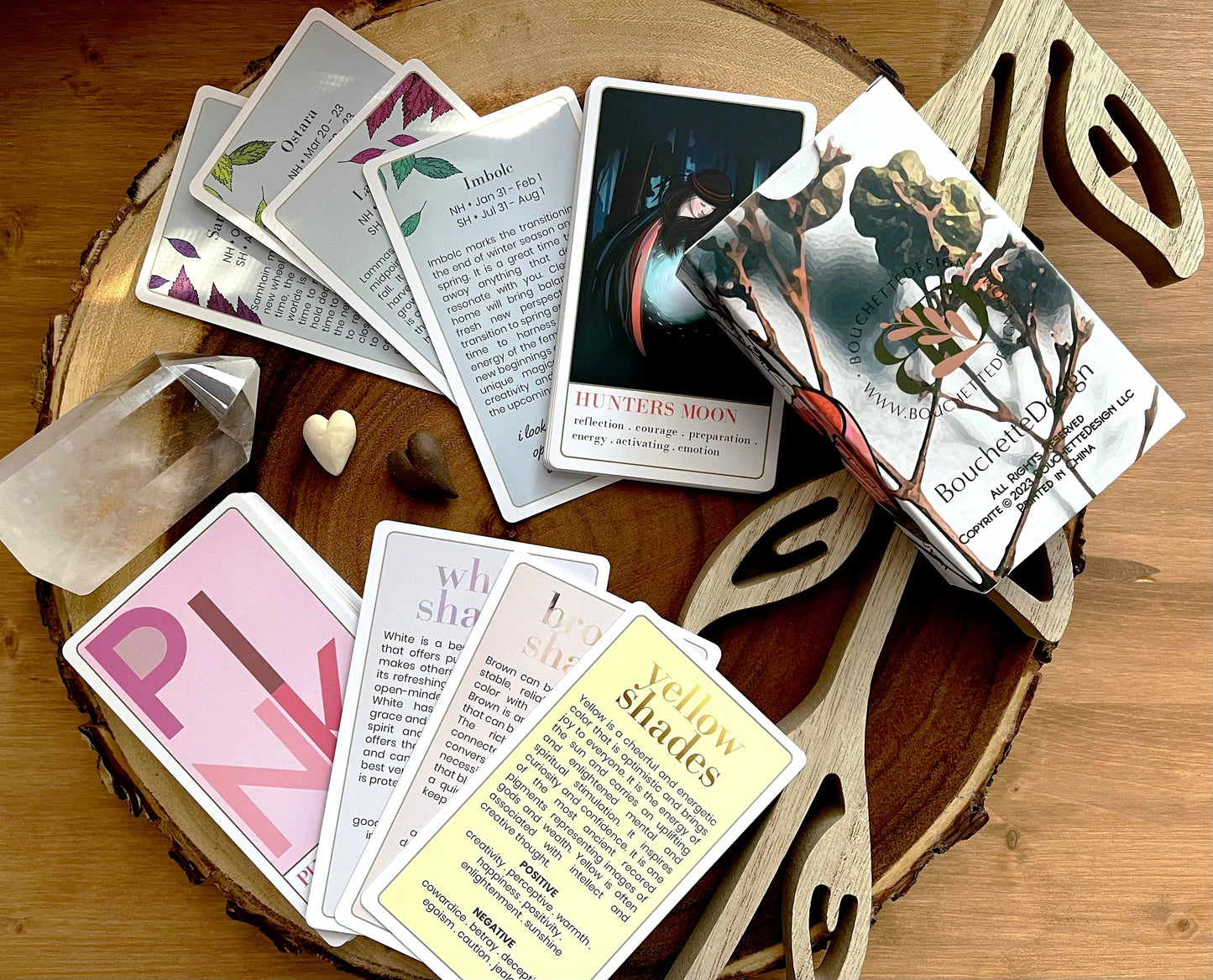 Collection of tarot cards on a wooden surface with decorative items. Wanderlust collection oracle deck