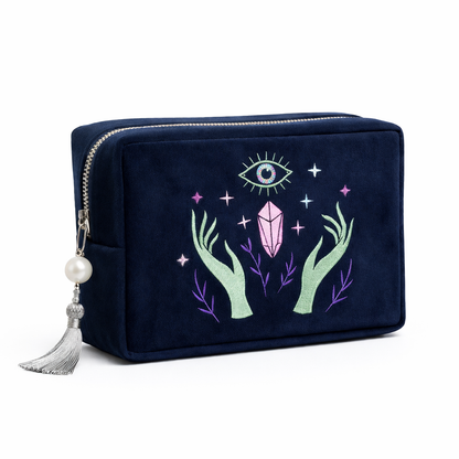 Navy blue pouch with embroidered design of hands holding a crystal and an eye symbol on a white background.