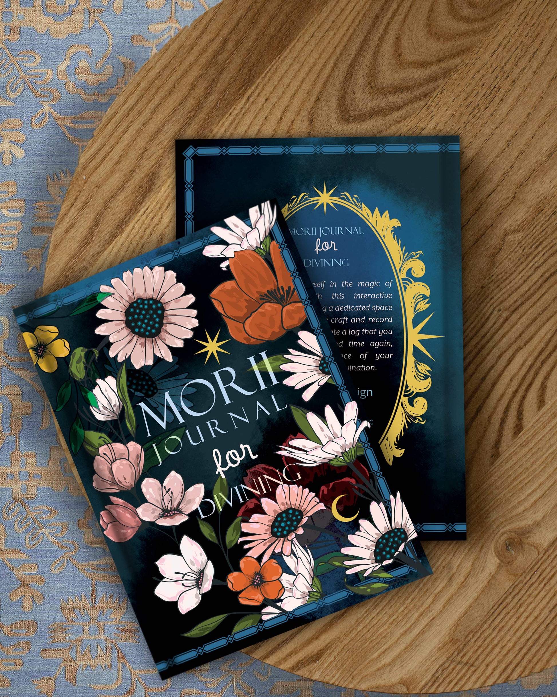 Two 'Morji Journal for Divining' on a wooden surface with floral designs.
