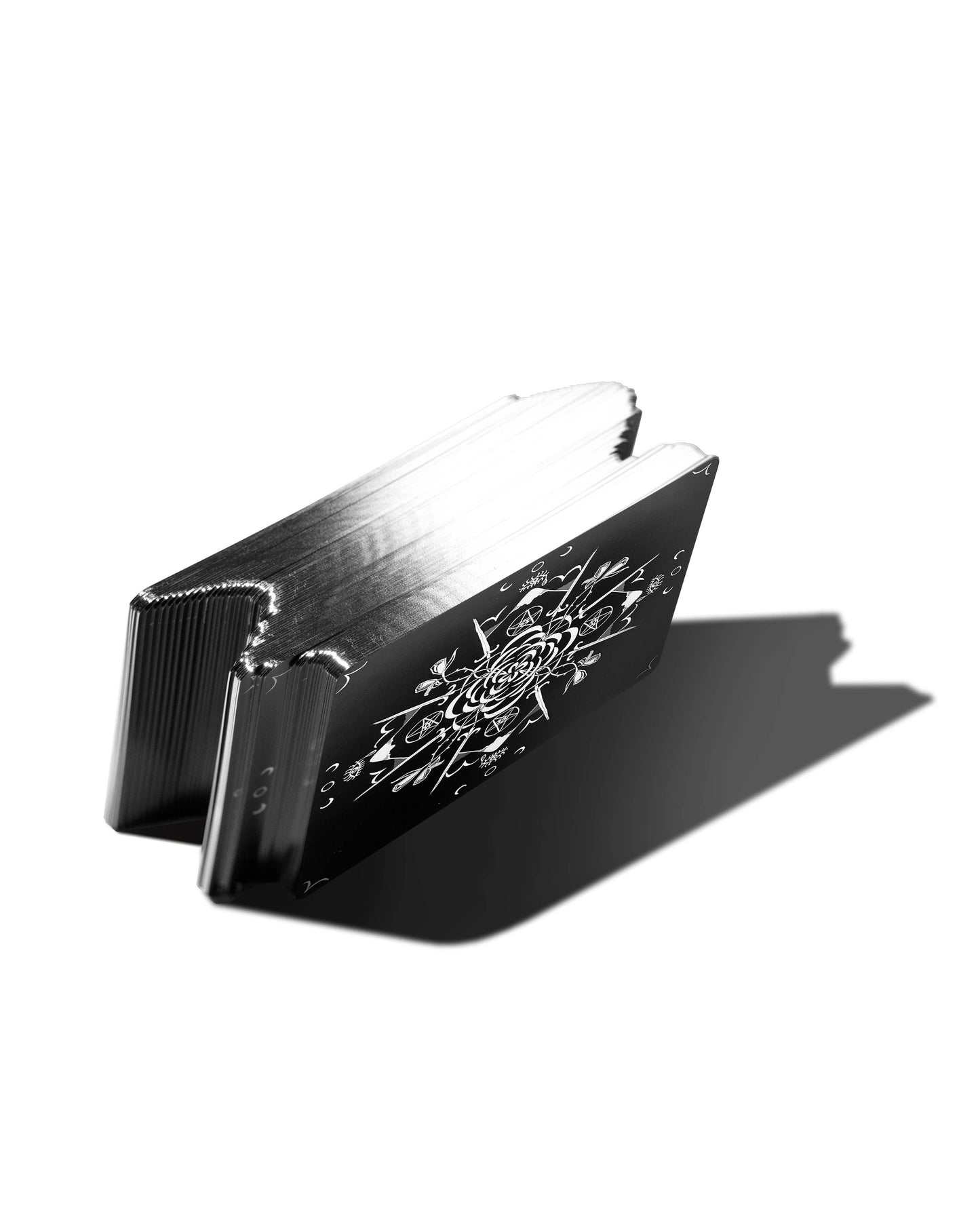 Black and silver wallet with intricate design on a white background Dark Days Tarot by Wren McMurdo Brignac featuring square black-and-white tarot cards inspired by the lunar cycle with a 180-page guidebook and collector's box.