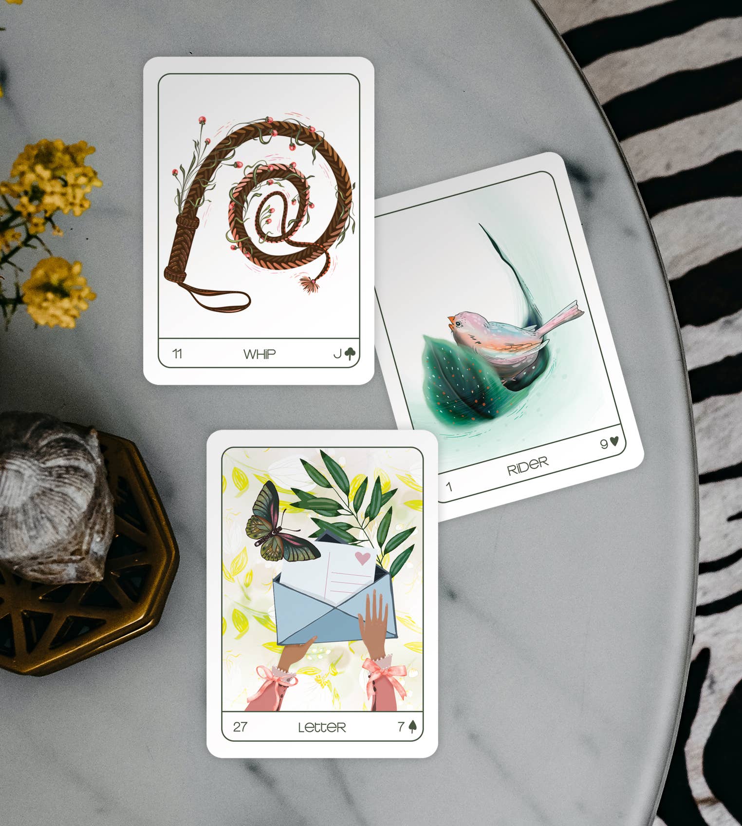 Three tarot cards on a marble surface with decorative elements.