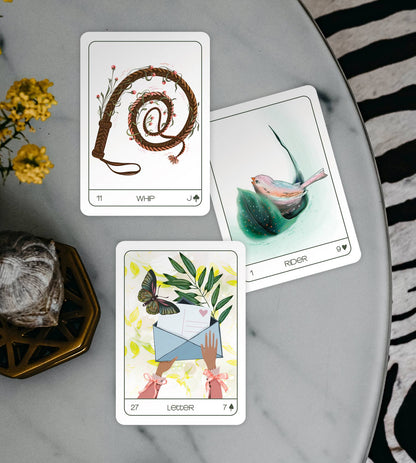 Three tarot cards on a marble surface with decorative elements.