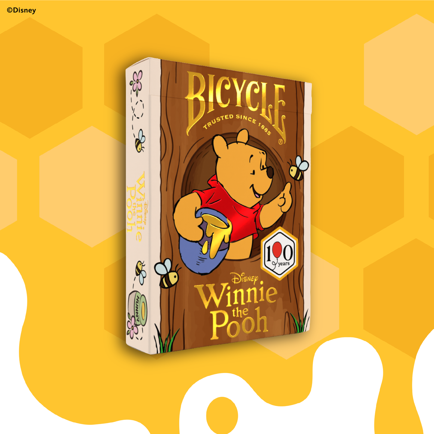 Bicycle Winnie the Pooh deck of cards on a yellow background with honeycomb pattern