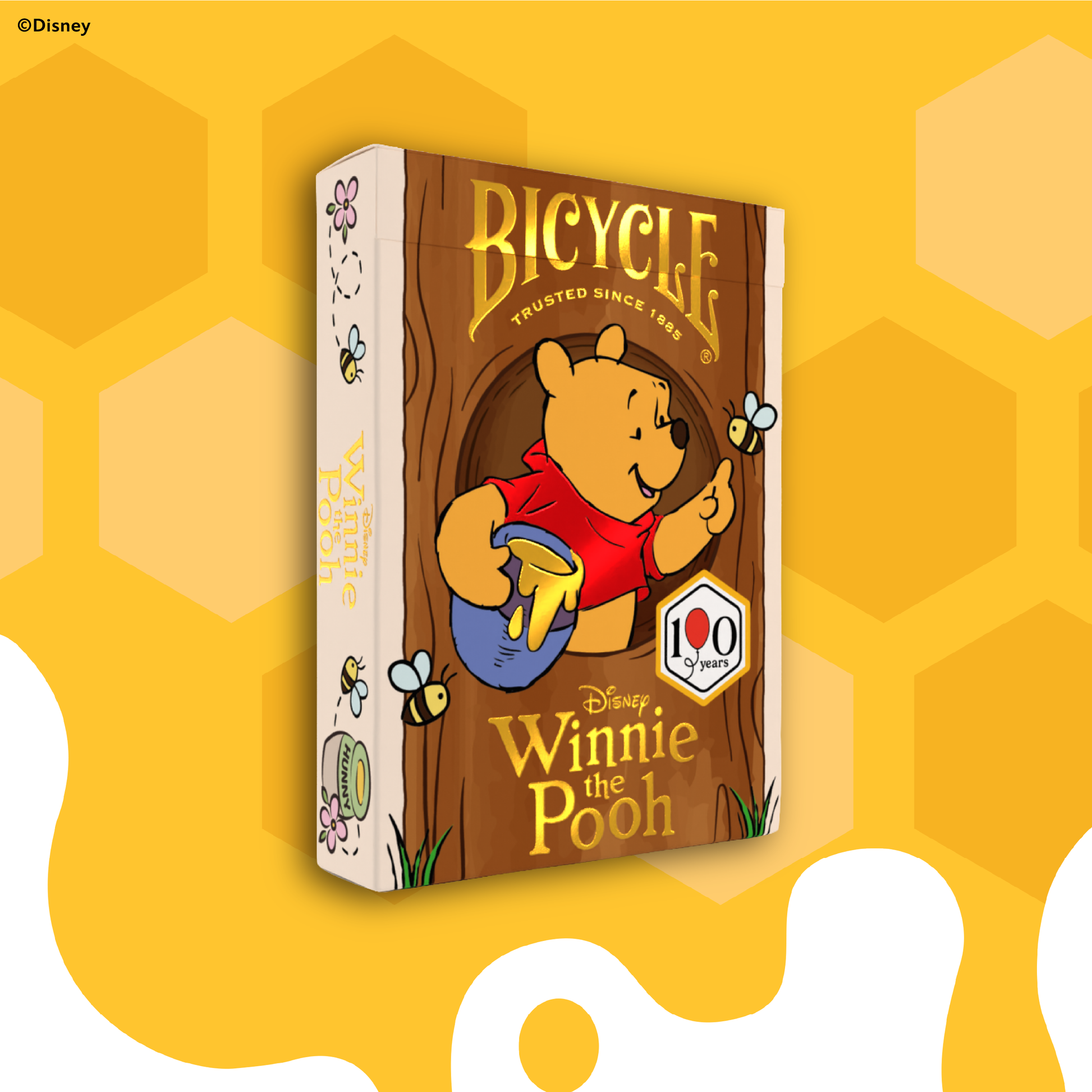 Bicycle Winnie the Pooh deck of cards on a yellow background with honeycomb pattern