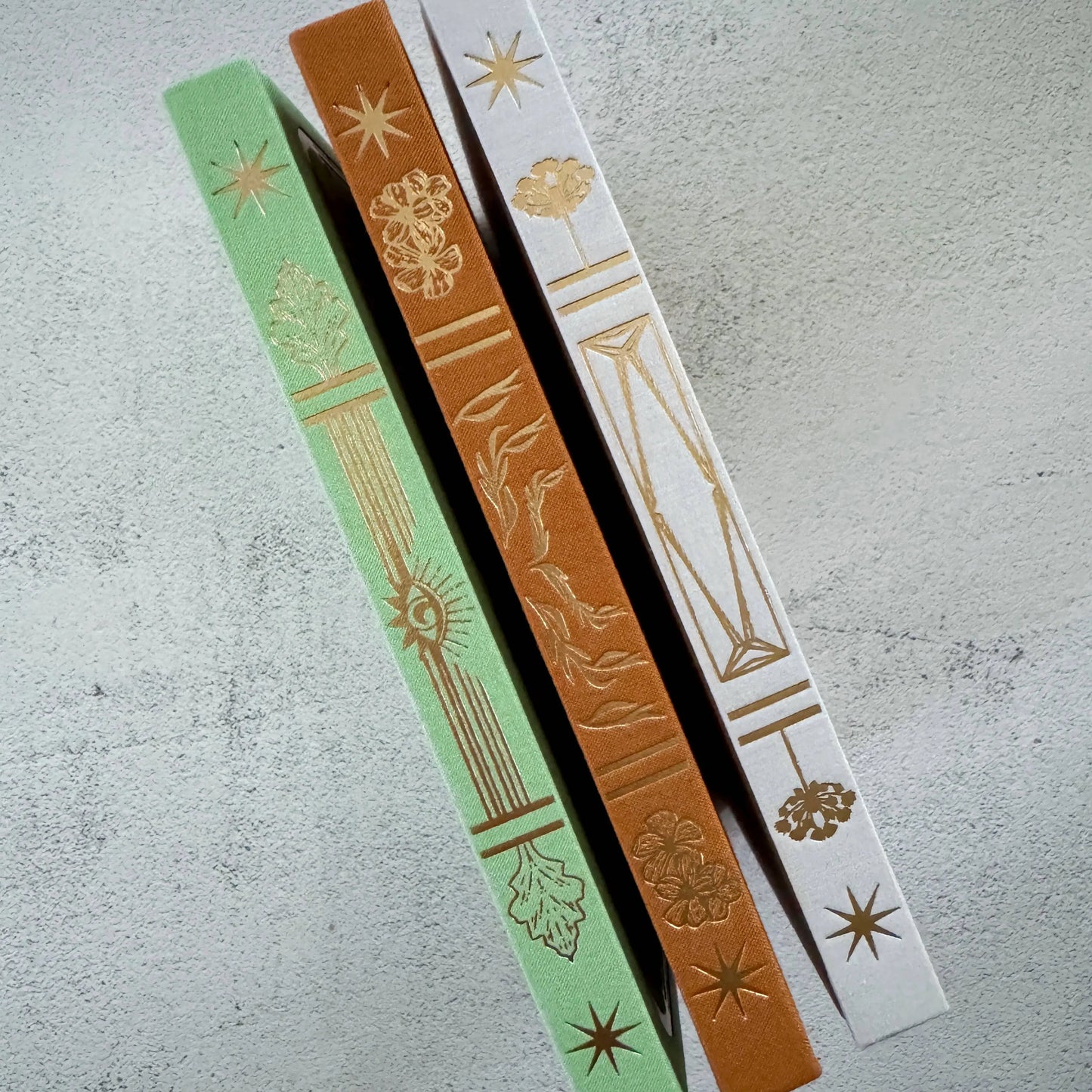 Three decorative ribbons with intricate patterns on a textured surface Tarot Journal Bouchette and Co Oneness Emporium