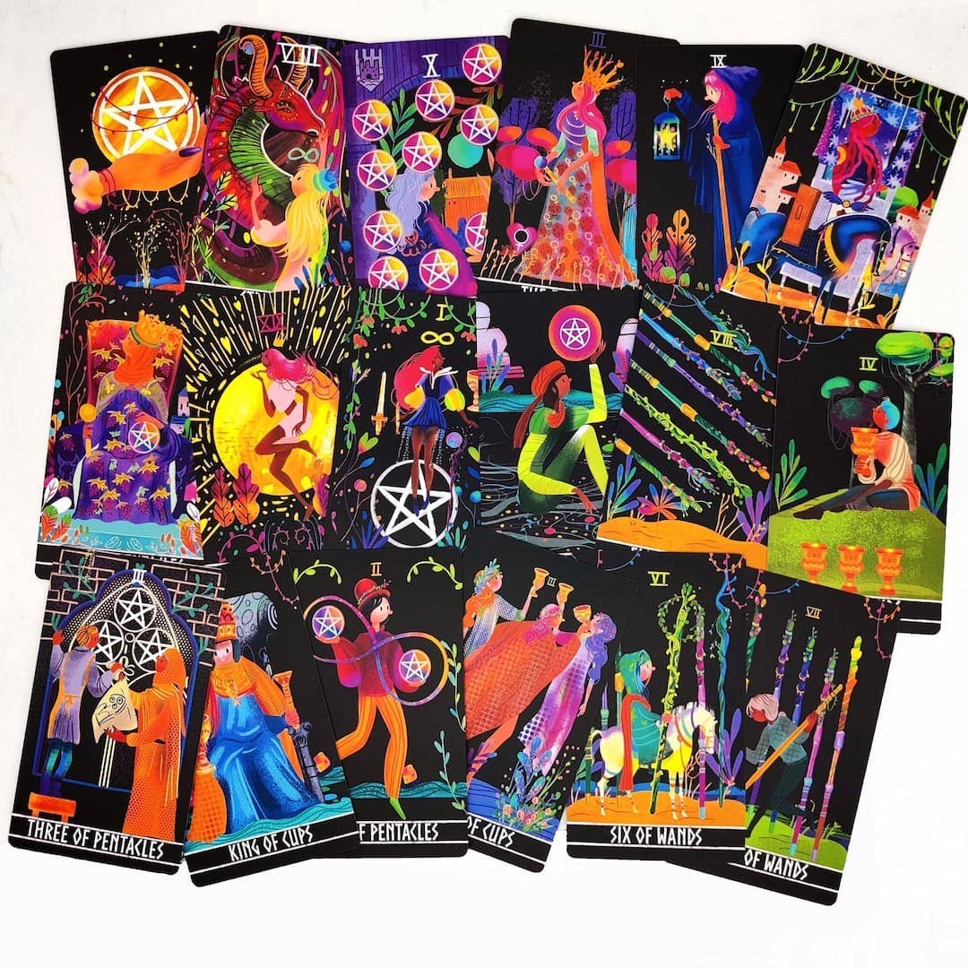 Collection of colorful tarot cards with various designs and symbols on a white background.
