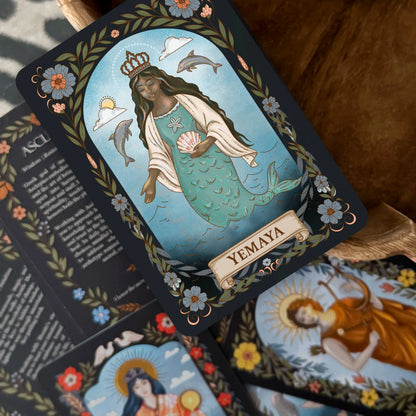 Card featuring a mermaid-like figure with 'Yemaya' at the bottom, surrounded by decorative elements.