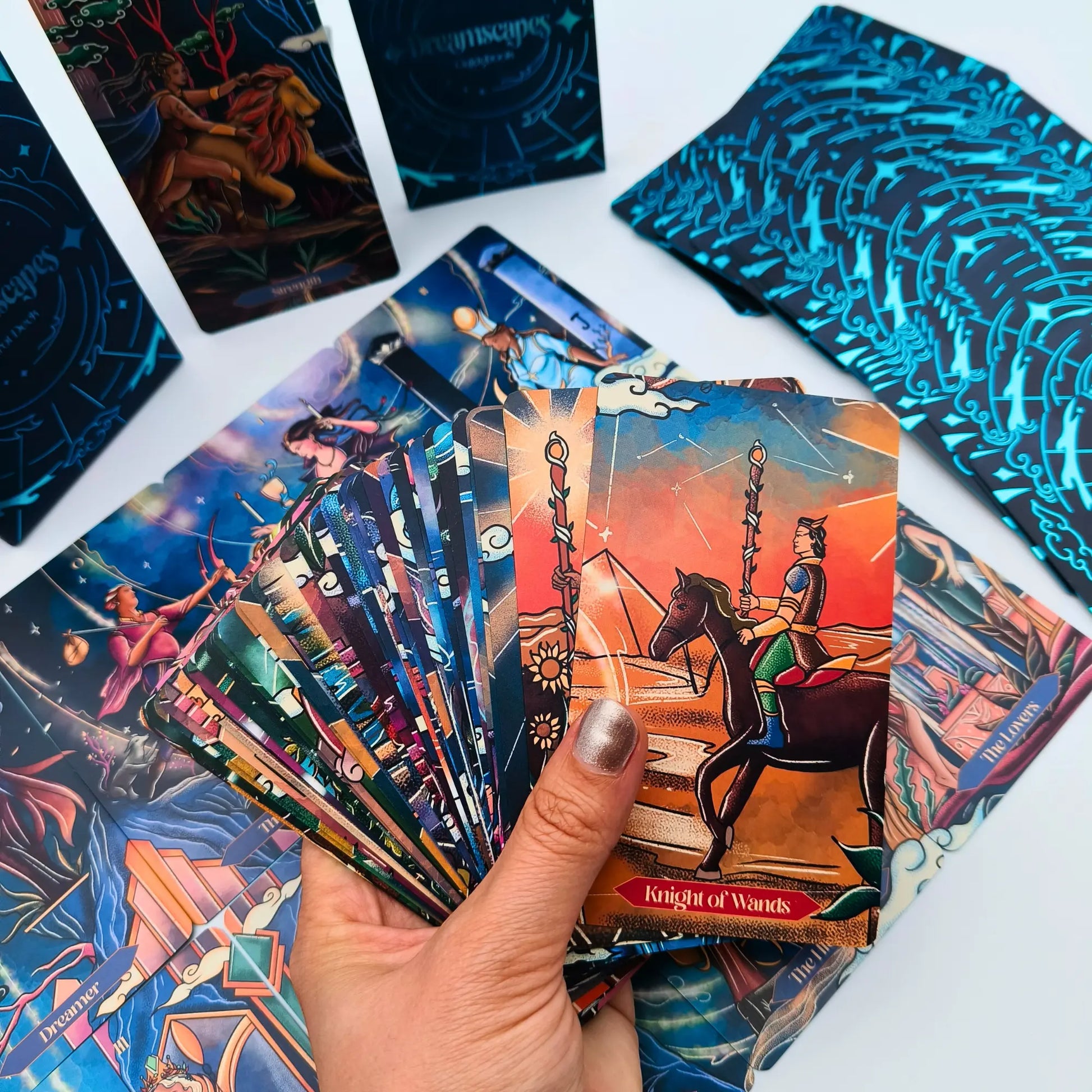 Colorful tarot cards with a hand holding one card, on a white background