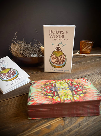 Oracle deck with 'Roots & Wings' packaging on a wooden surface