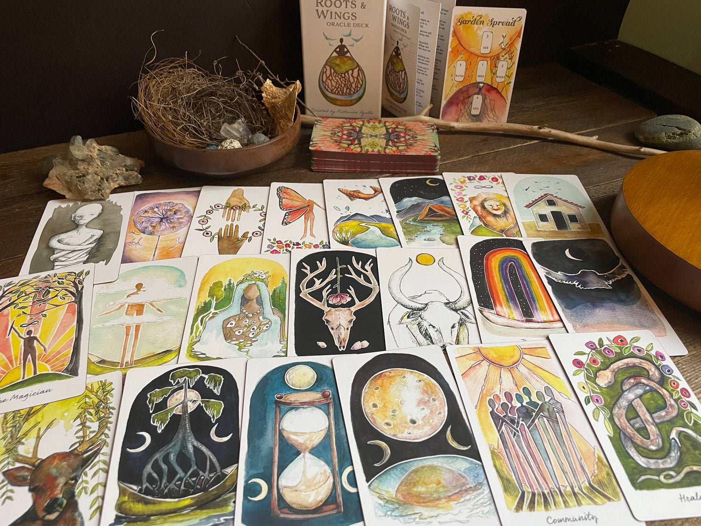 Collection of tarot cards and books on a wooden surface with natural elements.