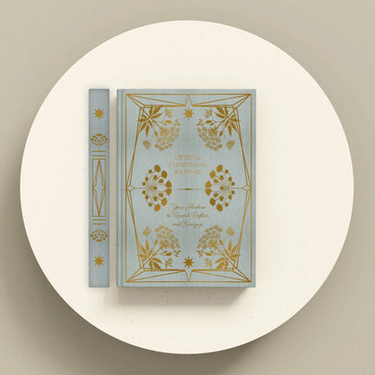 Decorative book with gold floral designs on a white platform Crystal companion journal by Bouchette and Co available from Oneness Emporium
