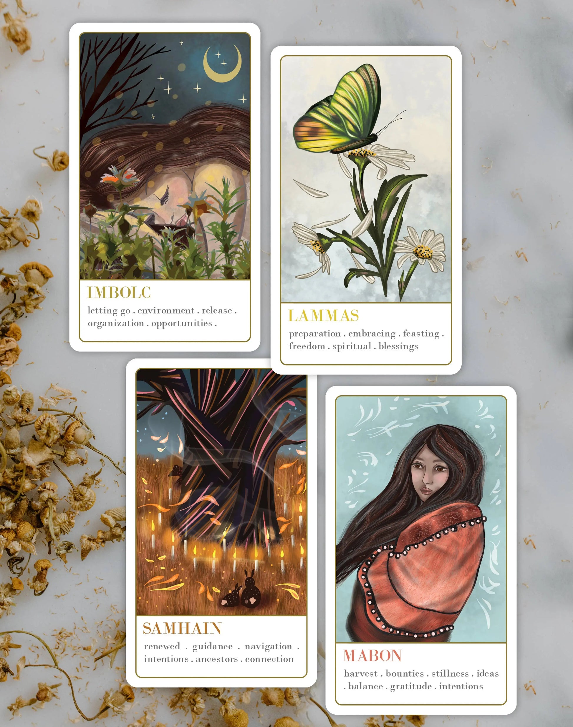 Wanderlust collection oracle deck Four tarot cards with illustrations and text on a light background with dried flowers.