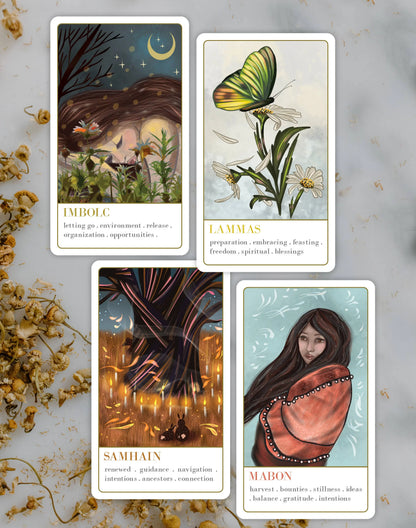 Wanderlust collection oracle deck Four tarot cards with illustrations and text on a light background with dried flowers.