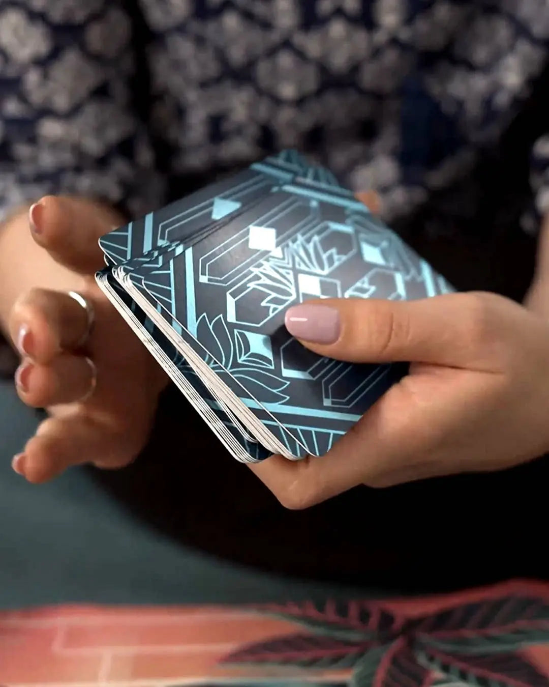 Person holding a deck of cards with geometric design