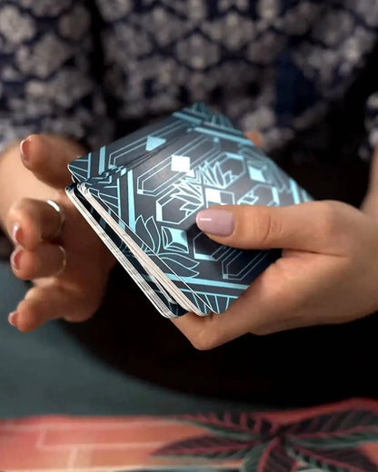 Person holding a deck of cards with geometric design